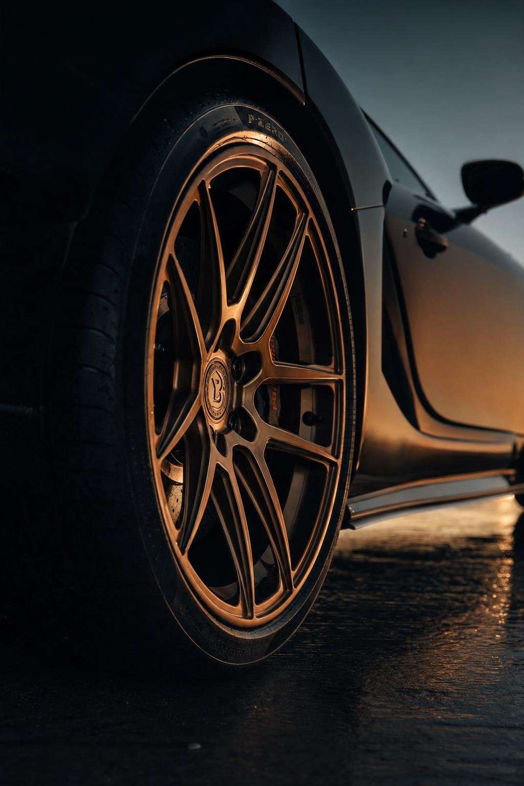 古銅金鍛造鋁圈裝於霧黑性能車，電影感暖光特寫